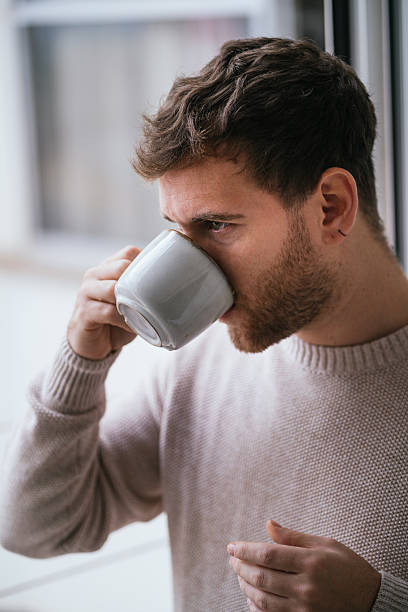 istock Young man drinking coffee or tea at home 2230726064