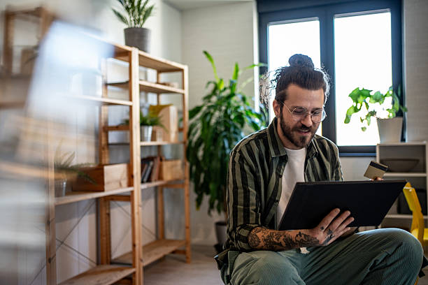 istock Young man making online payment using digital tablet and credit card at home 2230726346