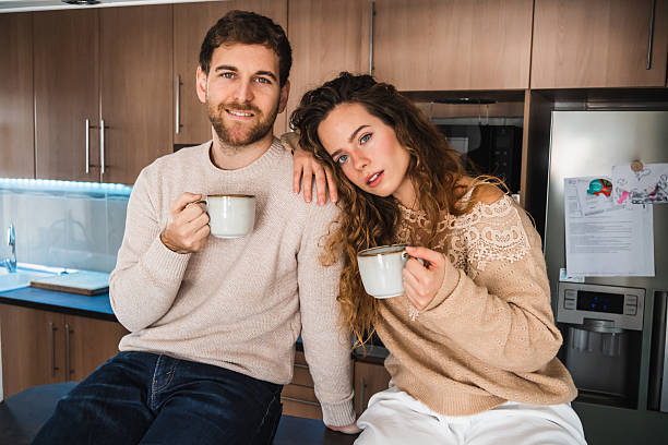 Young Caucasian cheerful couple making their first selfie in their new home.