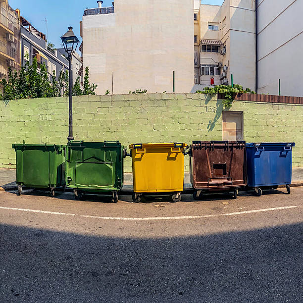 Row of multi colored plastic garbage bins in the street in the city of Valencia, Spain