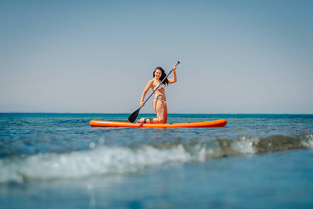 istock Young woman kneeling on paddle board in the sea 2230735229
