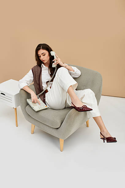istock Stylish young woman poses elegantly with a phone in a modern studio setting 2230737503