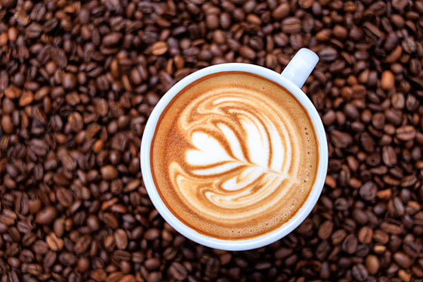 cappuccino white cup and roasted coffee beans backgrounds abstrack, top view