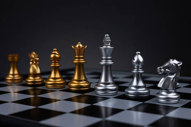 istock Gold and silver chess figures placed on wooden chessboard. Intellectual duel and tactical battle in business. 2230737893