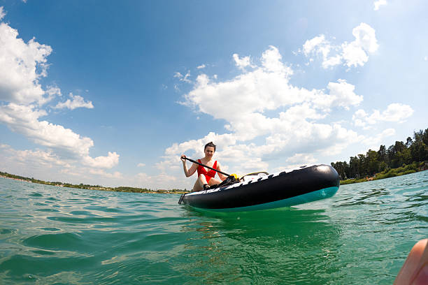 Young woman swimming on sup boards alone at sunset