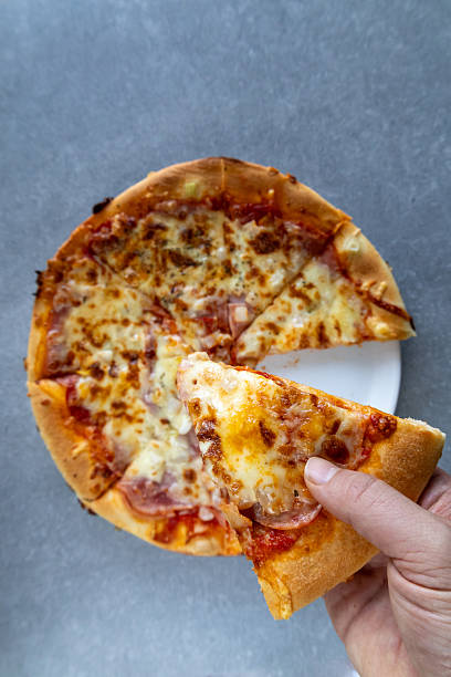 istock Holding a slice of pizza from a plate 2230738447
