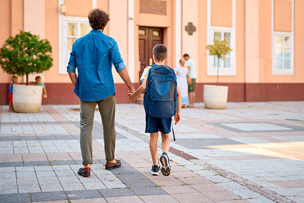 istock Father and son walking to school holding hands 2230739323