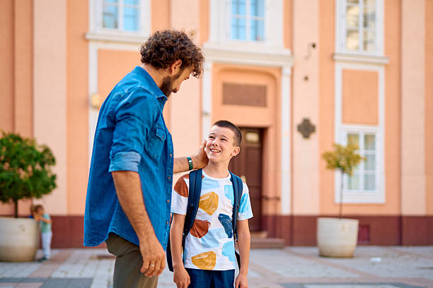 istock Father caressing his son's cheek in front of the school 2230739326