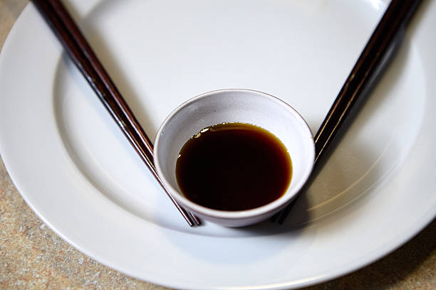 istock Close view of soy sauce in a bowl with chopsticks on dining table 2230739470