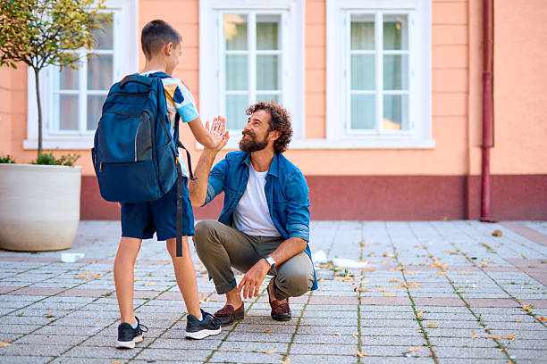 istock Father and son giving high five in front of school 2230739513