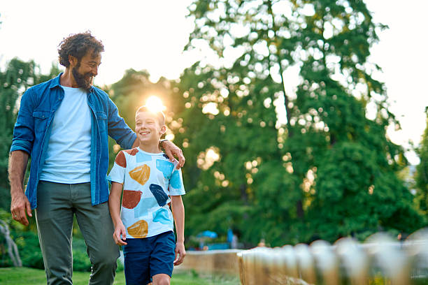 istock Father and son walking together in a park during sunset 2230739616