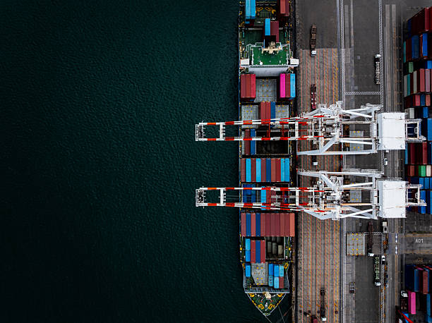 istock commercial port load and unloading cargo from container ship import export by crane for distributing goods by trailers transported to customers and dealers, 2230739860