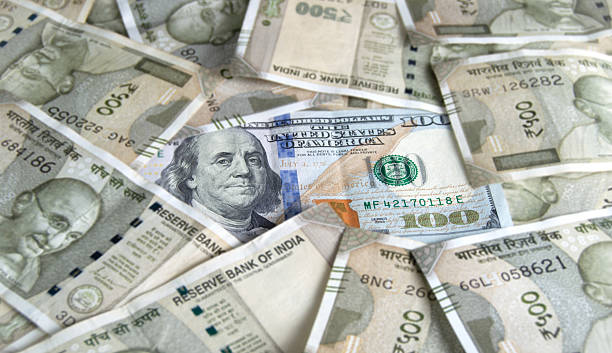 istock One hundred dollar US currency  paper note with a stack heap of 500 Rupees Indian currency full frame money cash background 2230740487
