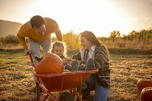 istock Family enjoying autumn pumpkin patch together 2230743030