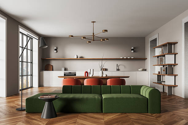istock Modern open space interior design with green sofa, wooden floor, and minimalist kitchen in stylish home concept featuring warm natural tones. 3D Rendering 2230743482