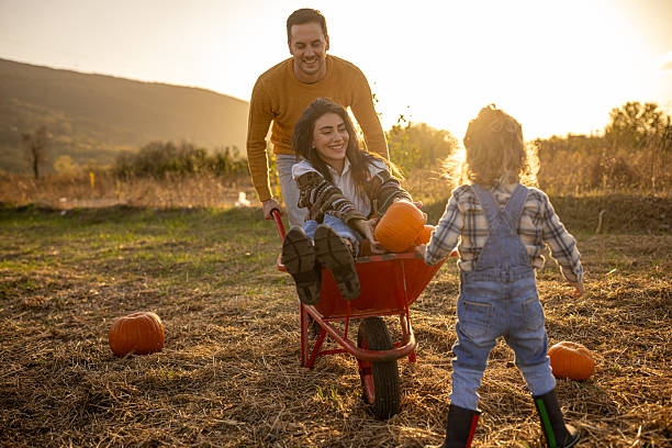 istock Family enjoying autumn pumpkin patch together 2230743485
