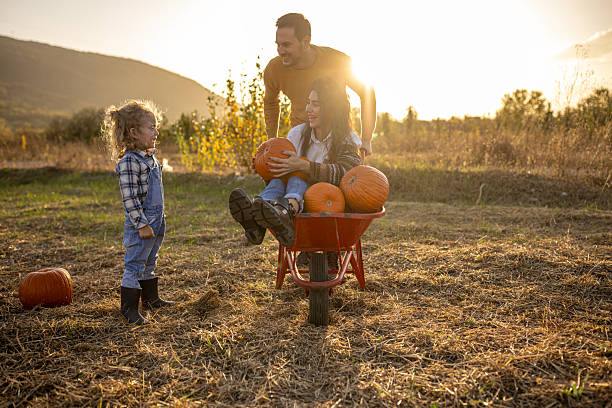 istock Family enjoying autumn pumpkin patch together 2230743812