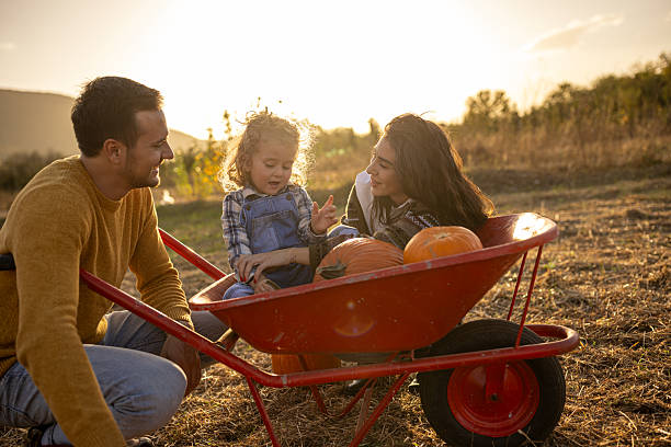 istock Family enjoying autumn pumpkin patch together 2230744374