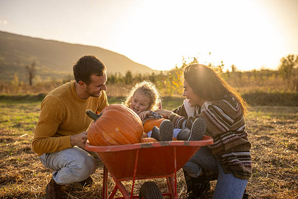 istock Family enjoying autumn pumpkin patch together 2230744441