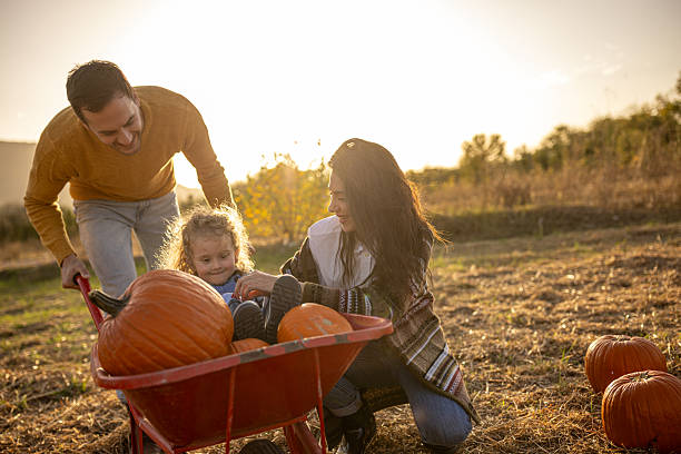istock Family enjoying autumn pumpkin patch together 2230745442