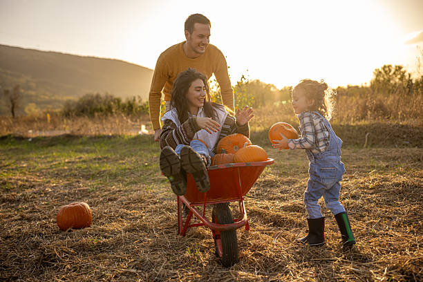 istock Family enjoying autumn pumpkin patch together 2230746657