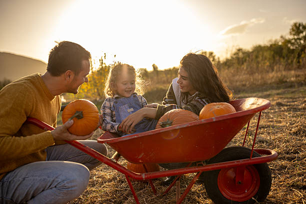 istock Family enjoying autumn pumpkin patch together 2230749051