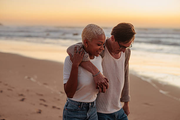 istock Happy couple walking on the beach at sunset, enjoying romantic stroll 2230753925