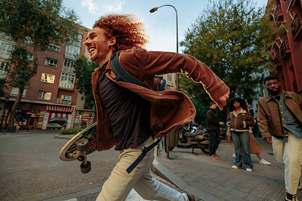 Young man running with skateboard in Madrid