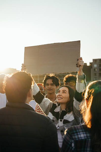 istock Young adults holding a sign during a peaceful outdoor protest 2230756532