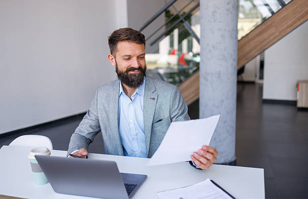 istock Businessman working at his desk in modern office reading documents 2230758913