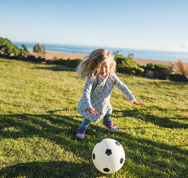 istock little kid playing soccer at the park 2230759646