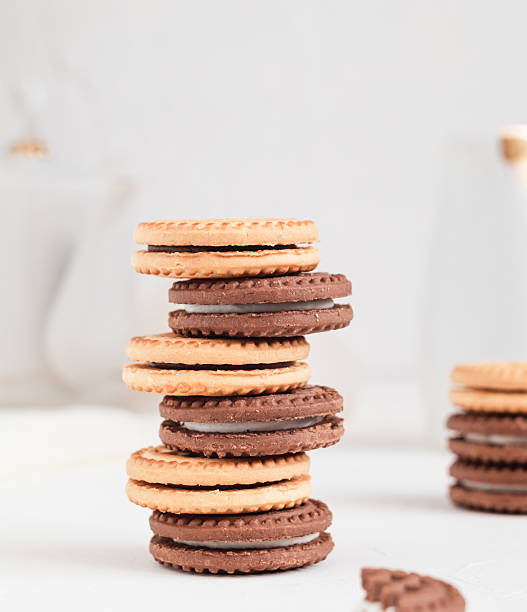 istock Stack of milk and chocolate cookies with cream close up on a white table. Bakery concept. 2230761244