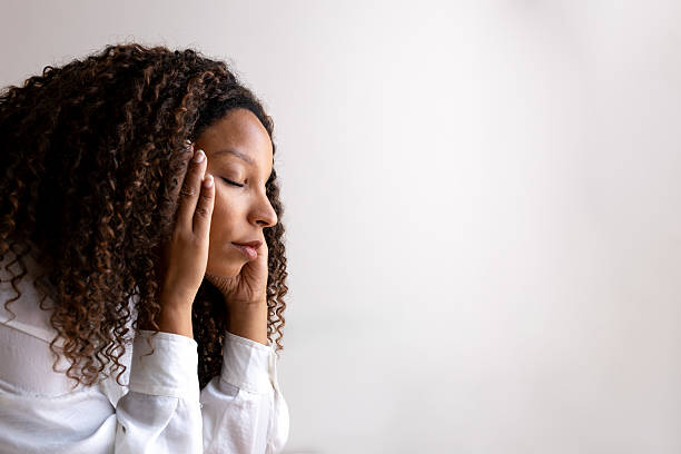 istock Young woman suffering from a headache touching her temples 2230761876