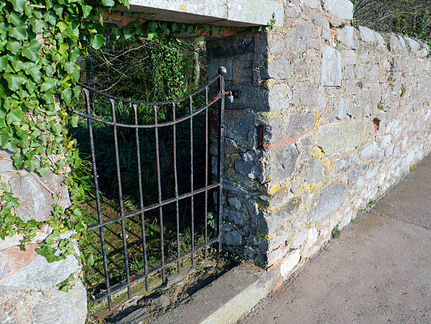 istock Old metal gate set into an old stone wall in England. 2230768028