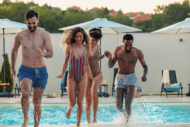 istock Friends running and splashing in swimming pool 2230770160