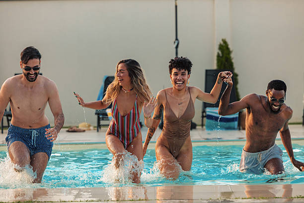 istock Friends running and splashing in swimming pool 2230770496