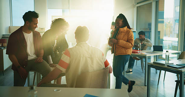 istock Education, student and group in classroom, talking or preparing for exam, lens flare and discussion. Happy, people and conversation with classmate in college, together and help for test and advice 2230771405