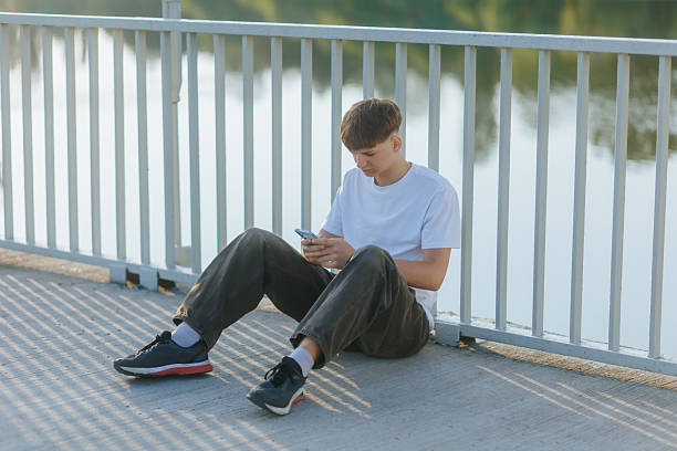 istock Teenager Deep in Thought, Using Smartphone Alone in the Park 2230774180
