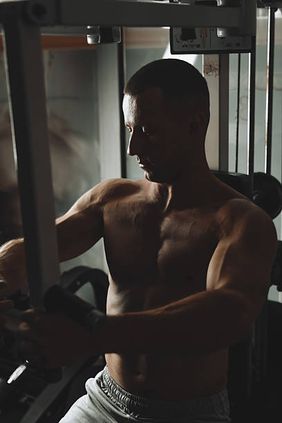 istock Muscular Male Executing Machine Chest Fly Workout In Gym With Concentration And Determination 2230777711