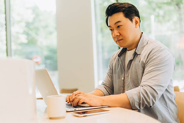 istock Asian freelancer working remotely on laptop in coworking space 2230779673