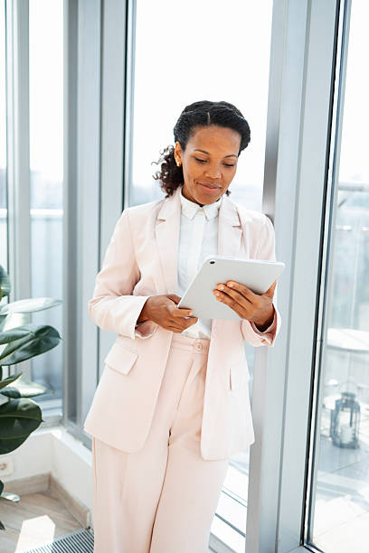 istock Businesswoman in light suit using tablet in a modern office environment 2230780802