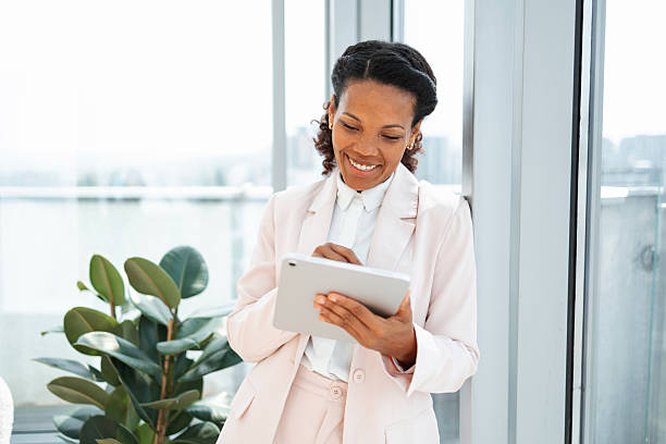 istock Professional woman using a tablet in a modern office with a smile 2230780803