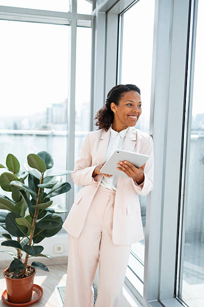 istock Confident professional woman using a tablet while standing in a modern office 2230780808