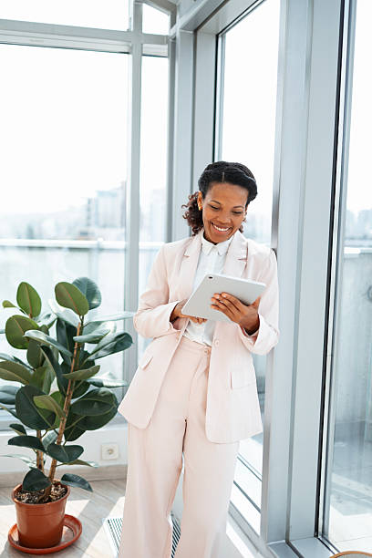 istock Young professional woman in a bright office holding a digital tablet 2230780809