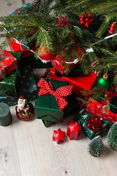 istock Traditional green and red gift boxes nestled beneath the Christmas tree, surrounded by glowing candles and festive decorations, creating a cozy and joyful holiday setting 2230781426