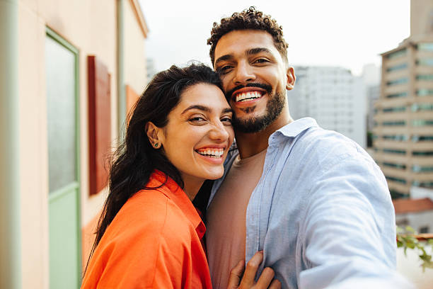 Happy couple taking a selfie on a city rooftop together