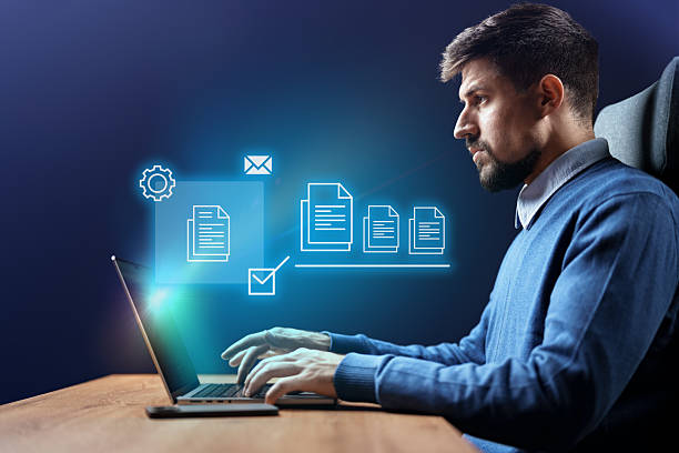 istock Young professional working on a laptop in a modern office displaying digital icons related to productivity and efficiency 2230781734
