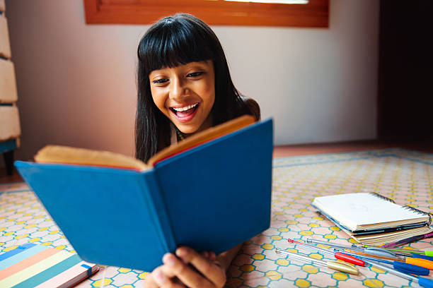istock Young girl reading a book at home during leisure time 2230782041