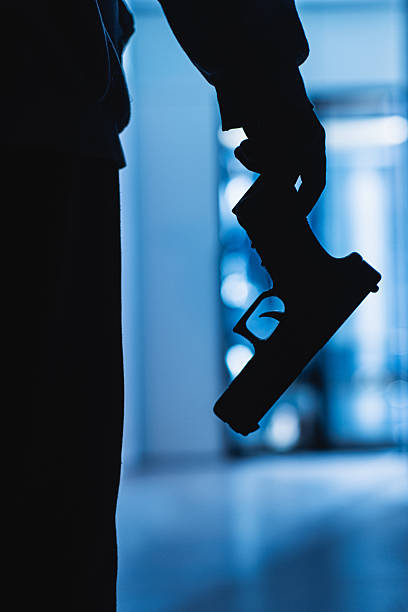 Killer. Gun in hand. Silhouette of man