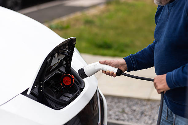 istock Man Charging Electric Vehicle at Home 2230785899